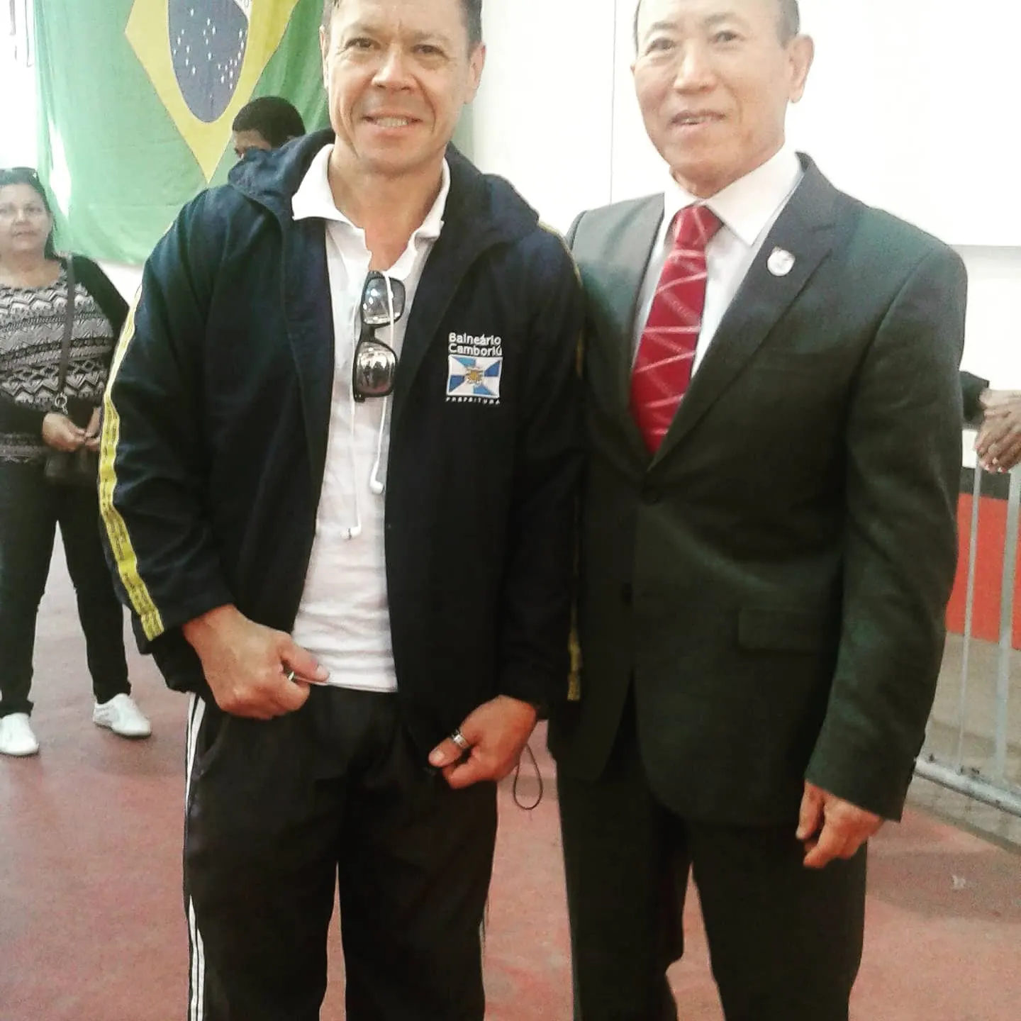 Mestre Paulo Ribeiro, com agasalho de Balneário Camboriú, ao lado do Grão-Mestre Te Bo Lee, de terno e gravata vermelha