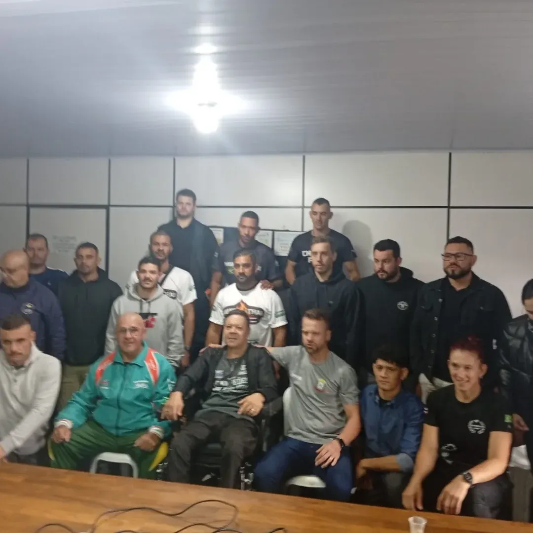 Técnicos e dirigentes de Muaythai reunidos numa sala em Pinhalzinho, com o Mestre Paulo sentado ao centro